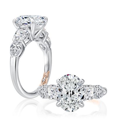 Modern 5 stone engagement ring with an oval cut center diamond. This heirloom ring has a cushion cut diamond and pear cut diamond on each side. 